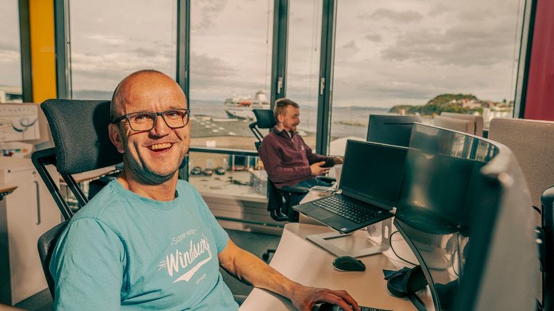 Strålende glad utvikler ved pulten sin på Trondheim-kontoret