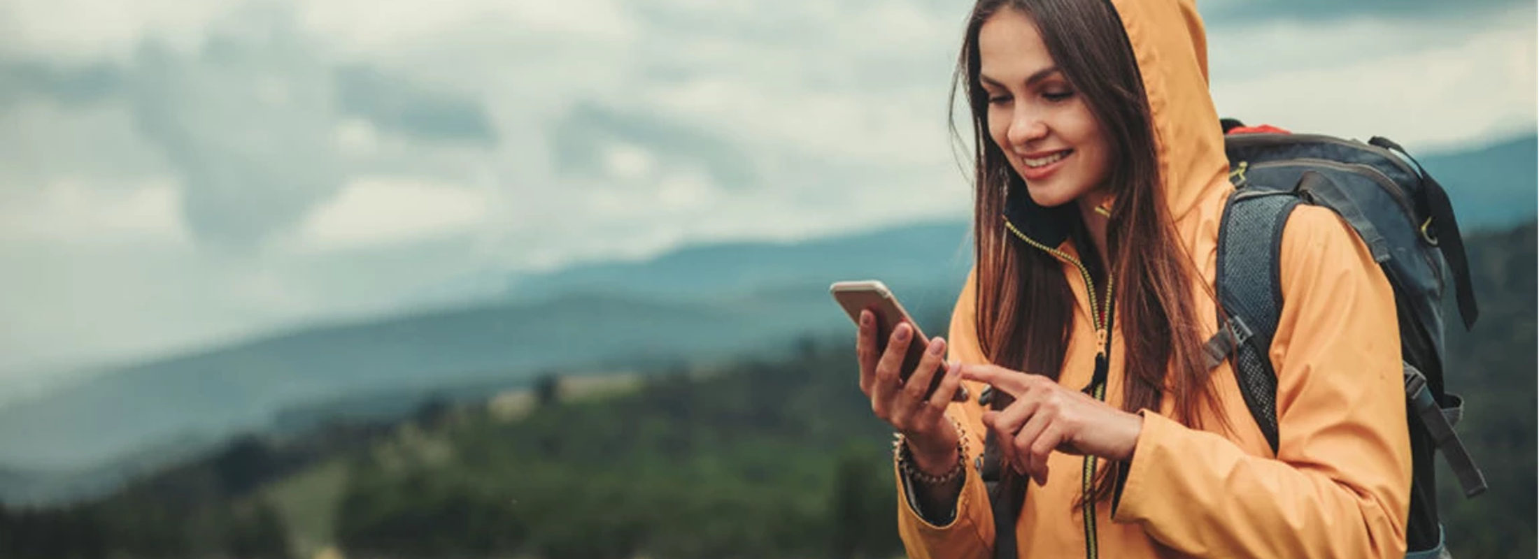 Kvinne på mobiltelefonen sin ute på tur