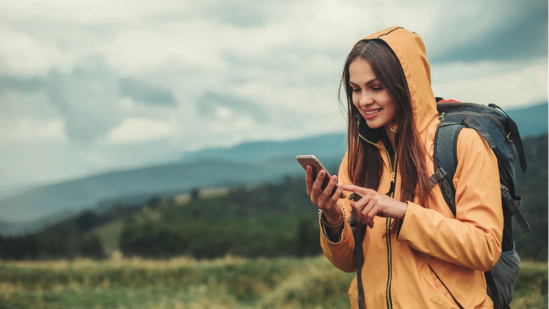 Kvinne på mobiltelefonen sin ute på tur